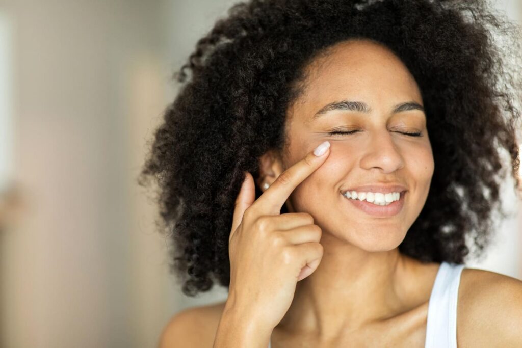 A woman applying the best tinted moisturizer