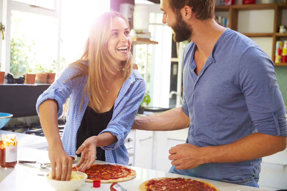 young couple enjoying cooking at home